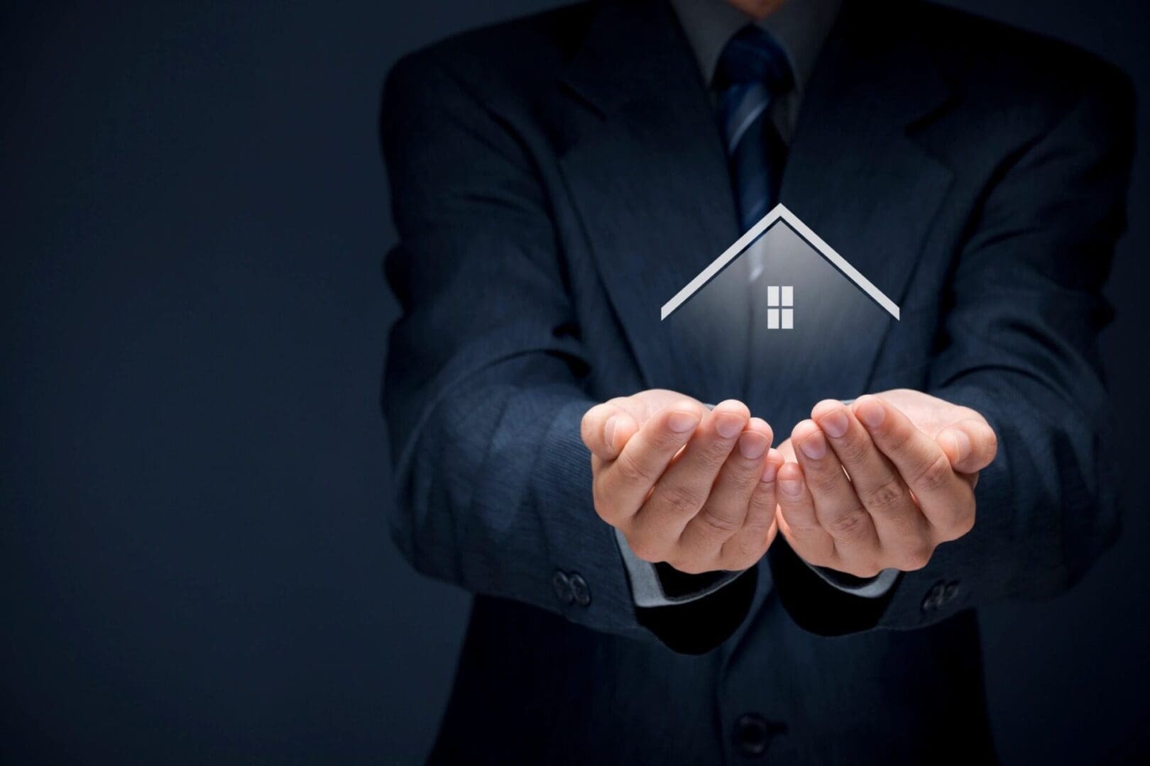 A person in a suit holding a graphical representation of a house in their hands.