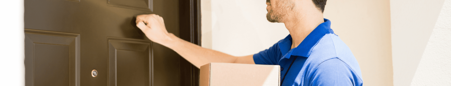 Delivery person knocking on a door while holding a package.