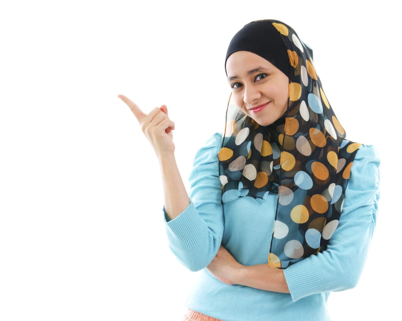 Woman in a hijab smiling and pointing to the side, presenting options for an Islamic mortgage vs. conventional mortgage.