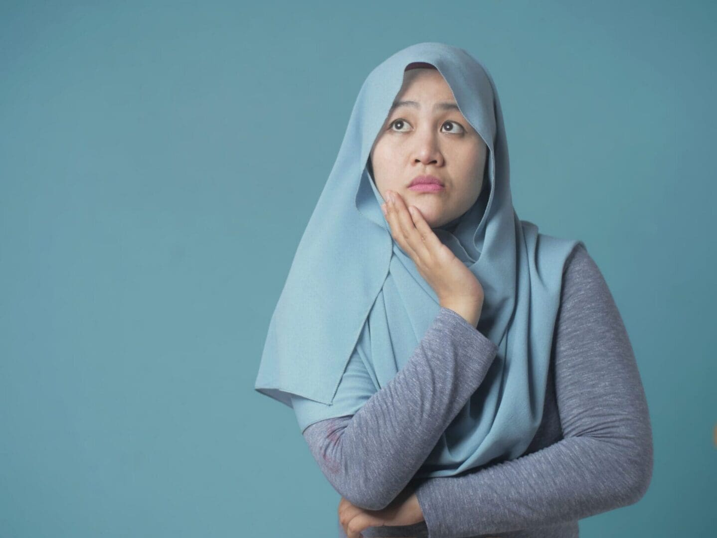 woman wearing a hijab wondering what the difference is between Islamic mortgage and a traditional one