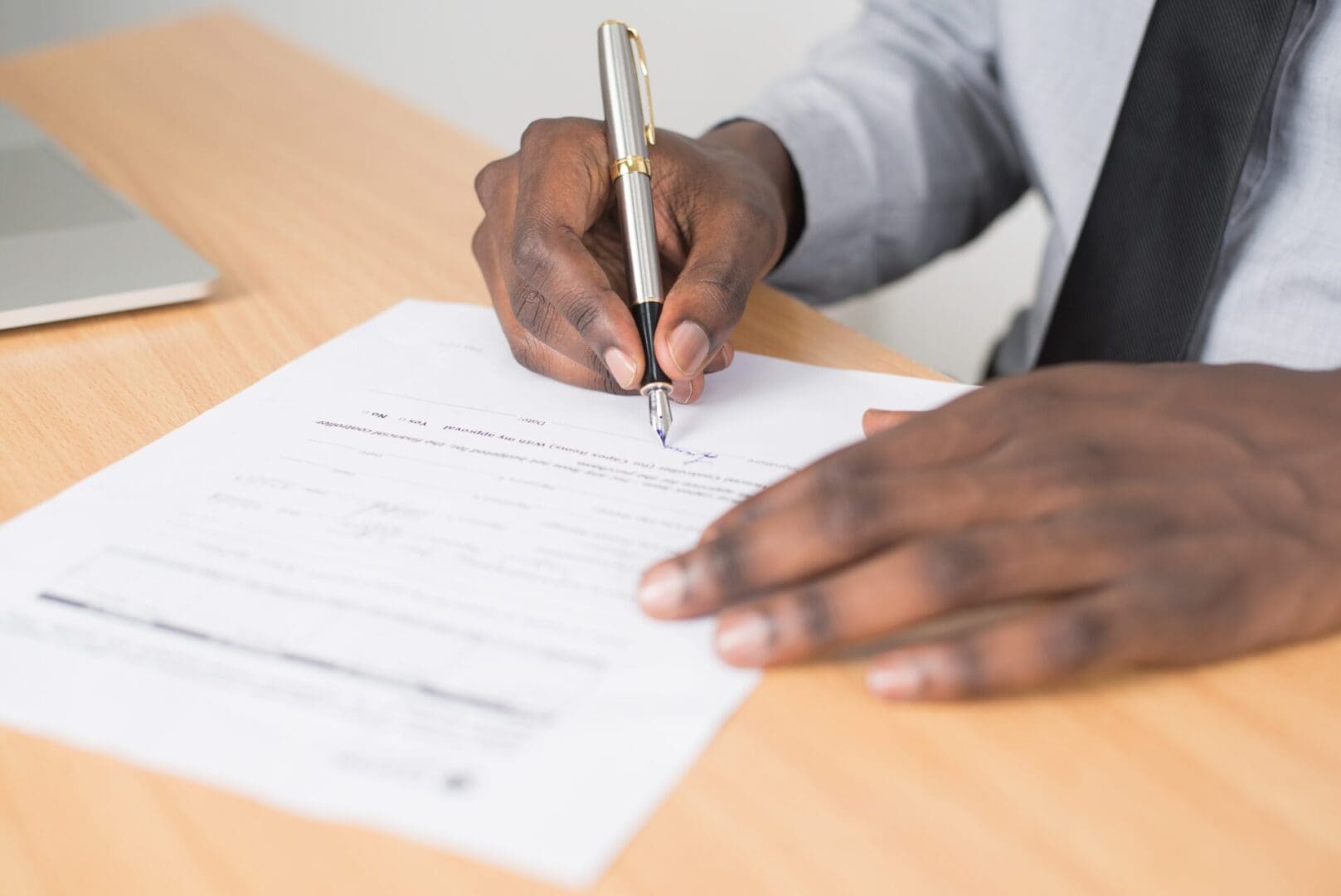 Person signing a lease document on a desk.