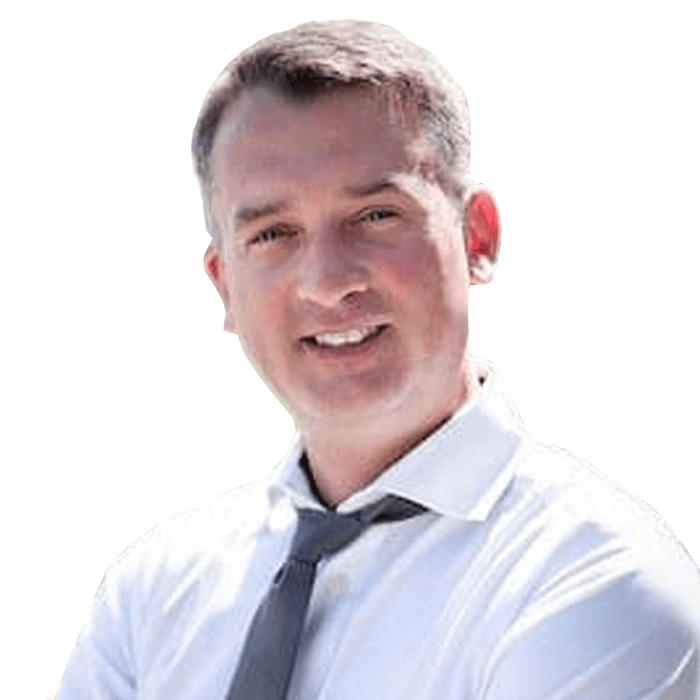 A man in a preferred white shirt and tie smiling against a white background.