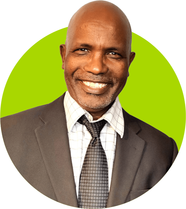 A smiling professional man in a suit against a green background.