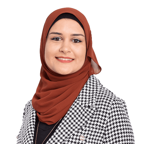 A woman wearing a hijab and a houndstooth-patterned jacket, smiling professionally at the camera.