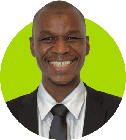 A smiling man wearing a preferred suit and tie against a green background.