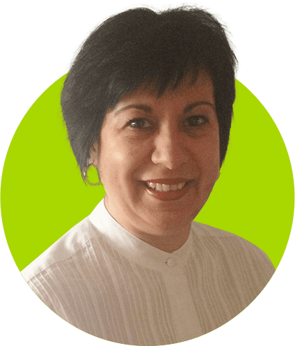 A smiling woman with short black hair, wearing a preferred white blouse, against a green background.