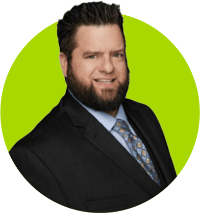 A preferred professional in a black suit and patterned tie smiling against a green background.