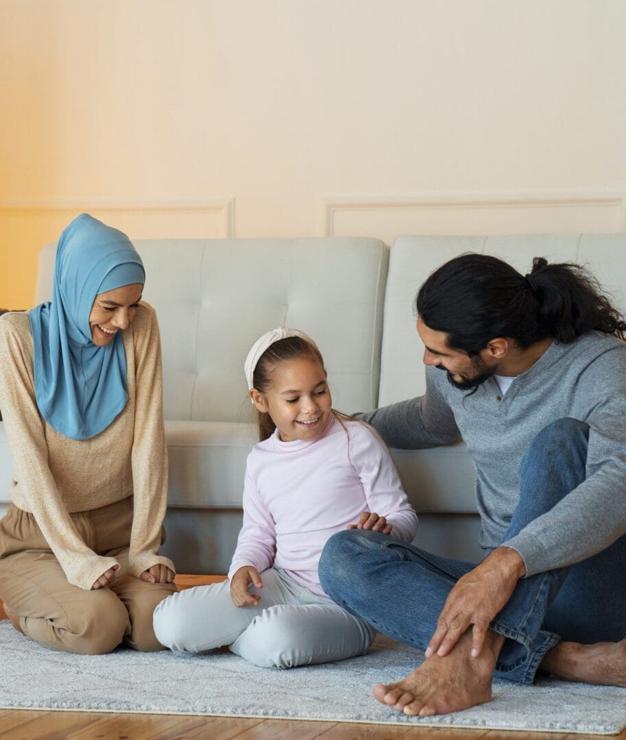 full-shot-happy-islamic-family-sitting-floor copy full shot of a happy islamic family living in a riba-free home via conversion