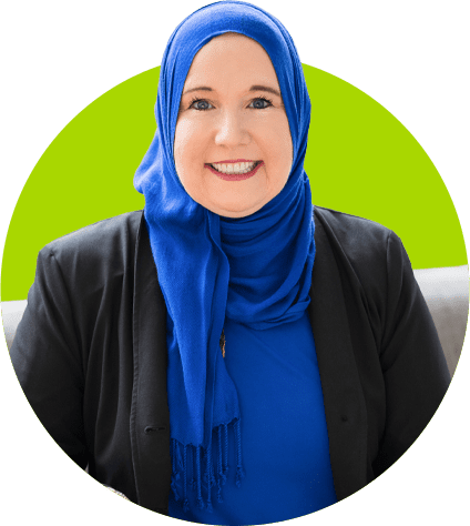 Smiling woman in blue hijab and jacket.