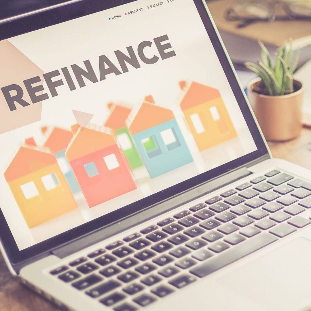 Laptop screen displaying the word "refinance" with colorful house icons, suggesting research or work on refinance documents and mortgage refinancing.