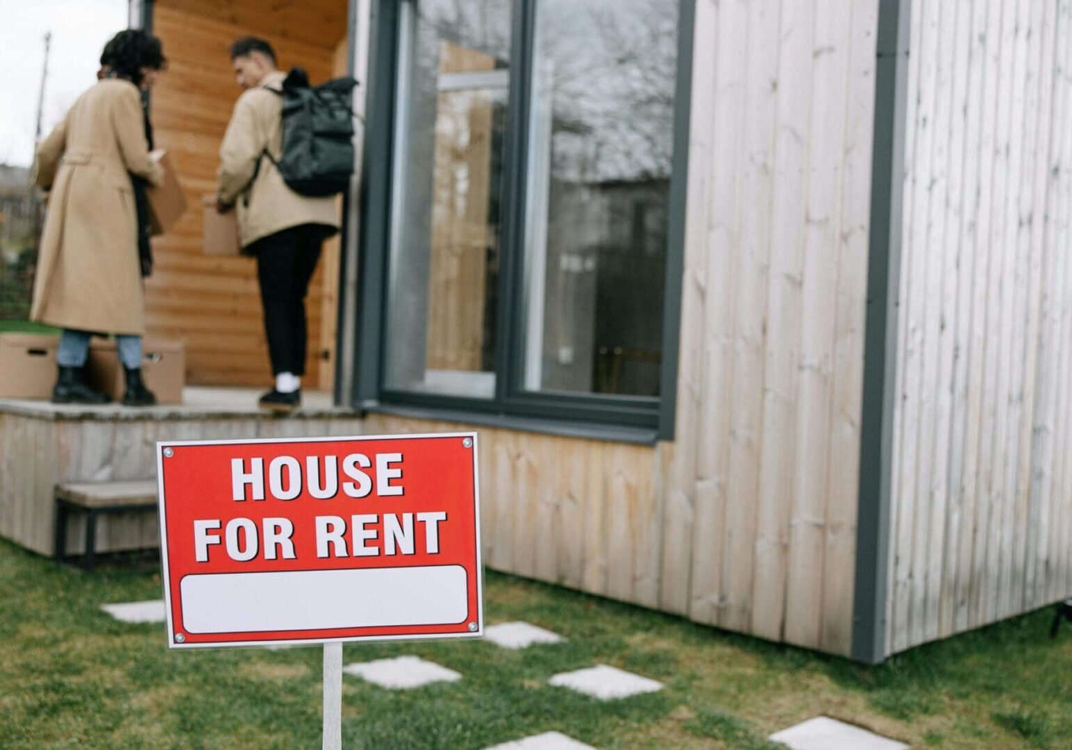 House for rent sign, people entering home.