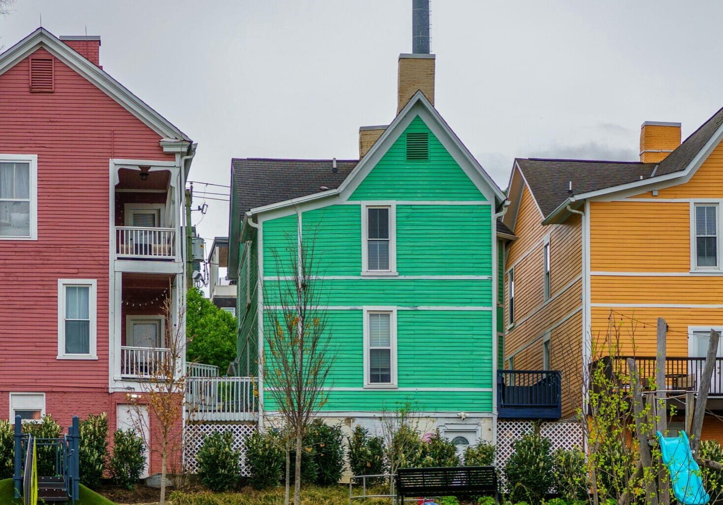 Colorful houses: pink, green, yellow in row.