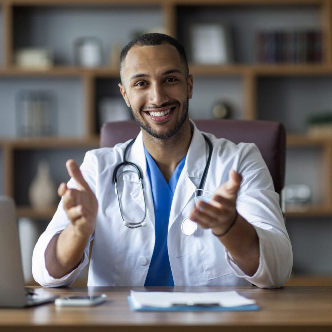 A smiling healthcare professional gesturing invitingly during a consultation in a US residential program. A smiling healthcare professional gesturing invitingly during a consultation in a US residential program.